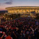 Vroege avondsfeer rond een Champions League-finale met supporters aan het stadion.
