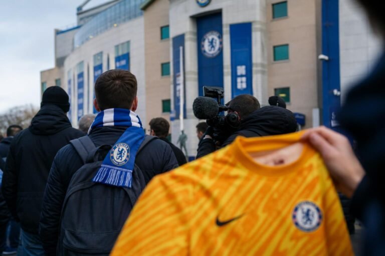 Transfercontext rond Chelsea-doelman met blauwe sjaals en perscamera's zonder herkenbare gezichten