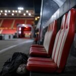 Voetbalbank in rood-witte stadioncontext bij het dossier rond Isaac Babadi