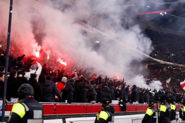 Gespannen Ajax-supporterssfeer op een stadiontribune zonder herkenbare gezichten