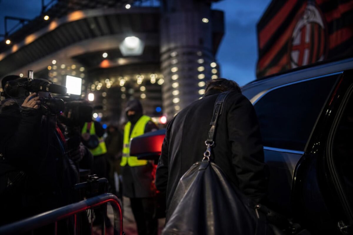Transfercontext rond AC Milan met gespannen stadionomgeving zonder herkenbare gezichten