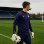 Doelman in jeugdcontext met handschoenen op een trainingsveld