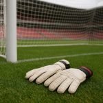 Doelmanstraining bij Manchester United met keepershandschoenen en netten op de achtergrond