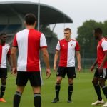 Beeld van een speler in Feyenoord-trainingsoutfit op het oefenveld, met focus op transfersfeer zonder herkenbare gezichten.