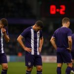 Spelers van RSC Anderlecht druipen teleurgesteld af in het stadion na een wedstrijd.