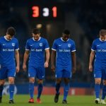 Teleurgestelde spelers van KRC Genk in een stadionomgeving na een wedstrijd