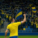 Spelers van STVV vieren een moment in geel-blauw in het stadion