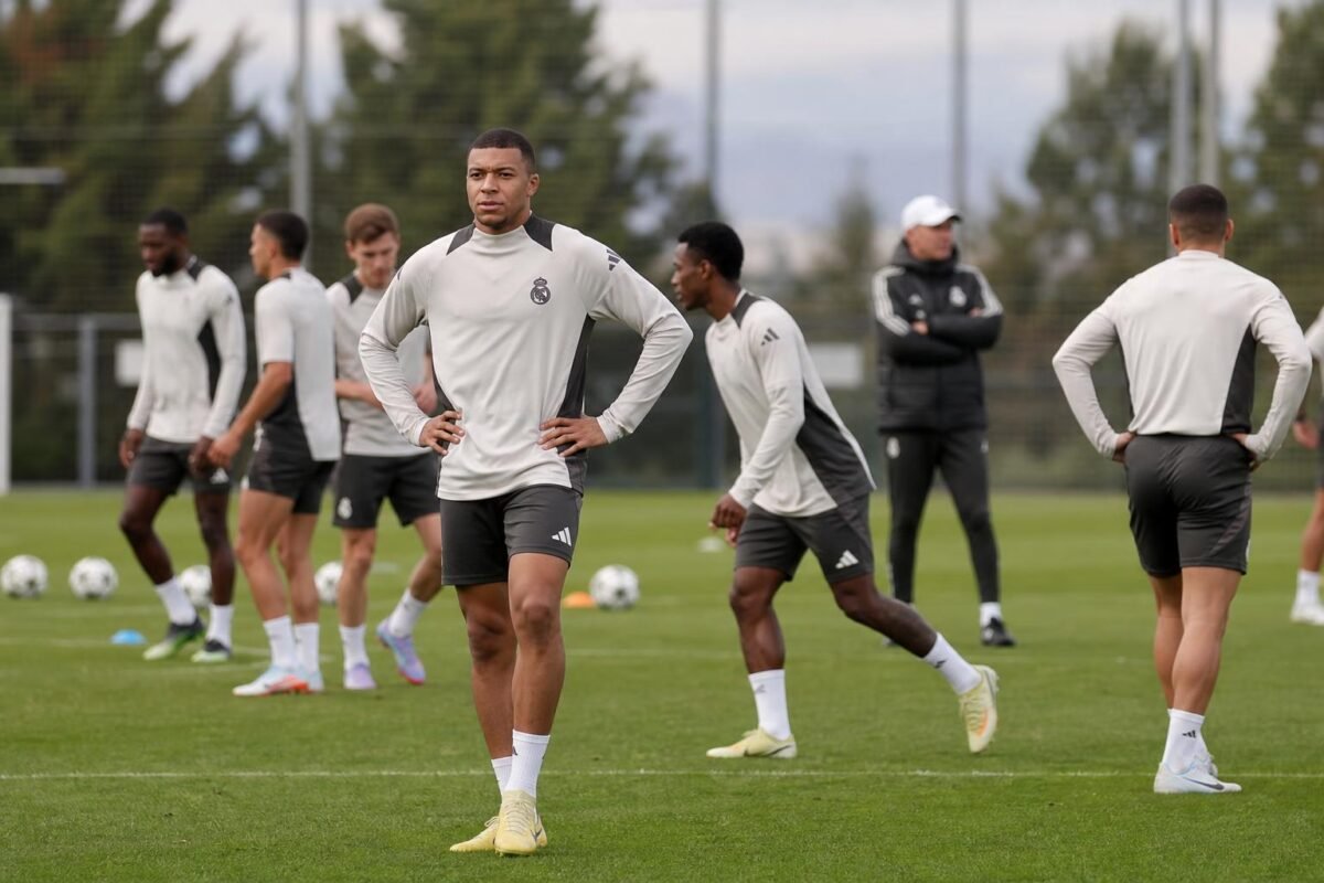 Spelers van Real Madrid op training in een gespannen sfeer, gefotografeerd vanop afstand zonder herkenbare gezichten.