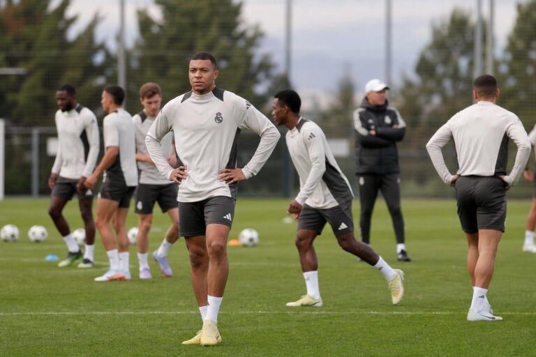 Spelers van Real Madrid op training in een gespannen sfeer, gefotografeerd vanop afstand zonder herkenbare gezichten.