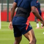 Sfeerbeeld van een speler in Manchester United-trainingskledij tijdens een revalidatiemoment op het oefenveld