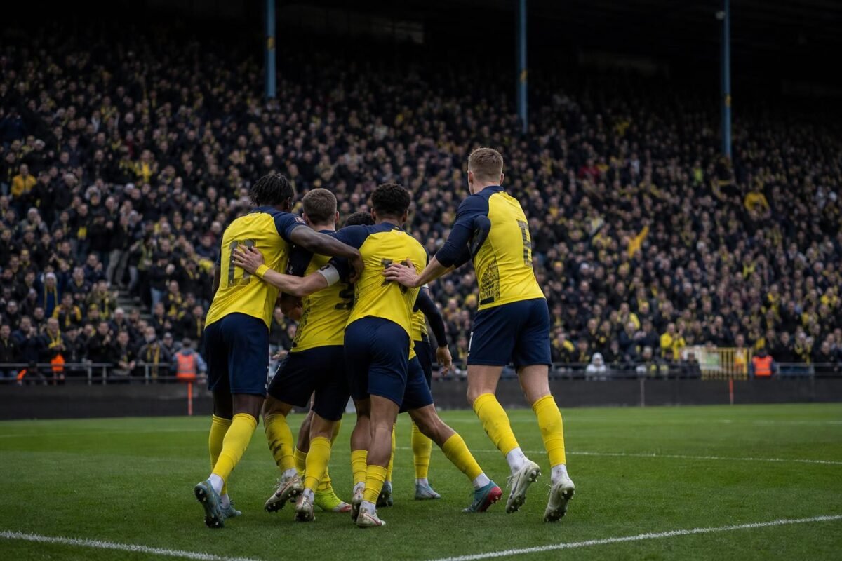 Spelers van Union SG vieren na een overwinning, met focus op de spanning richting Jan Breydel.