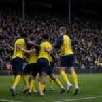 Spelers van Union SG vieren na een overwinning, met focus op de spanning richting Jan Breydel.
