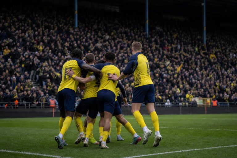 Spelers van Union SG vieren na een overwinning, met focus op de spanning richting Jan Breydel.