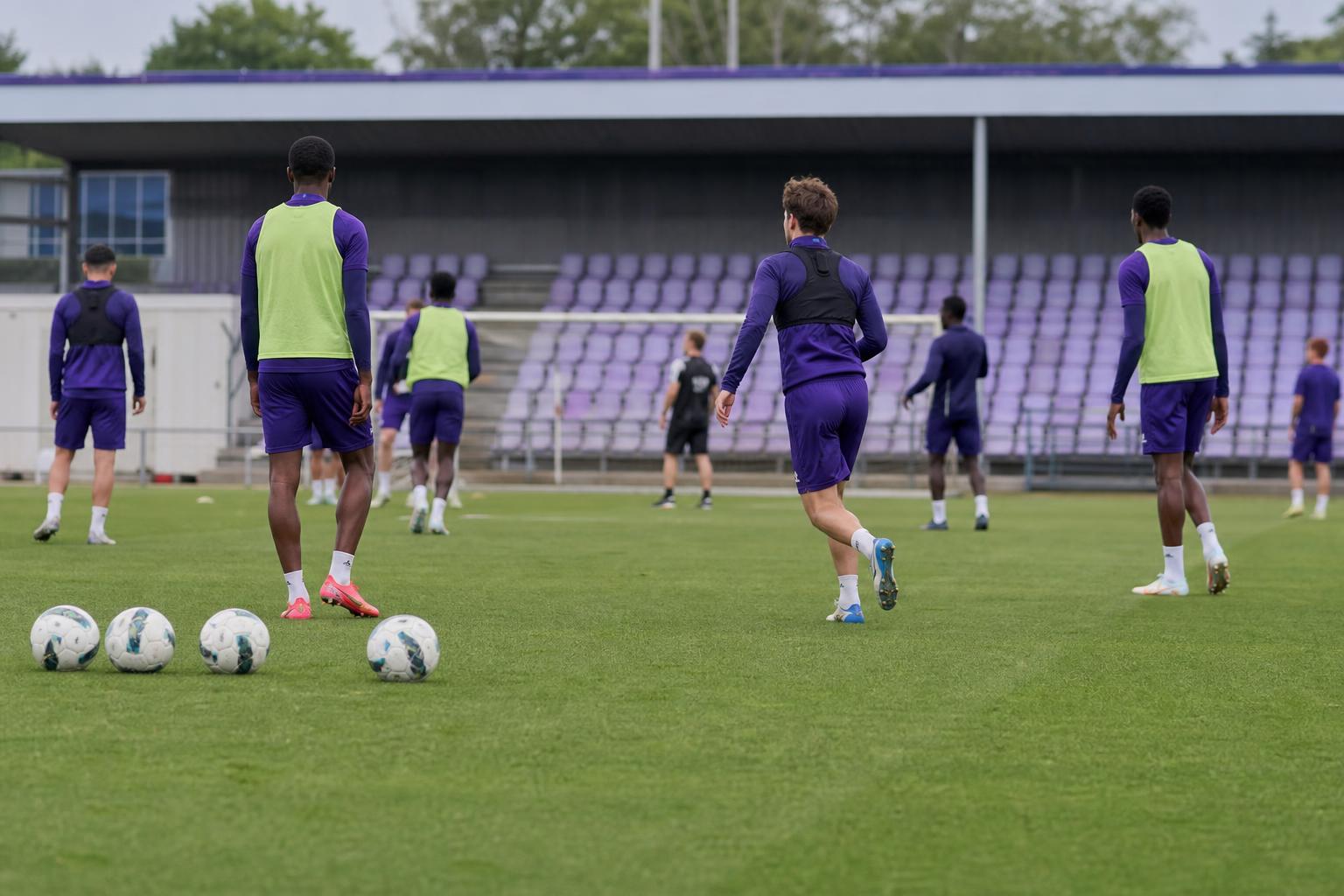 Spelers van RSC Anderlecht op training, gezien vanop afstand zonder herkenbare gezichten.
