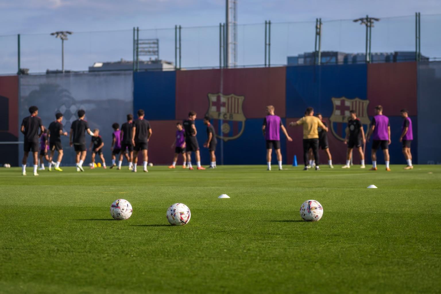 Trainingssituatie bij FC Barcelona met spelers op het veld, terwijl de focus ligt op de voorbereiding zonder herkenbare gezichten.