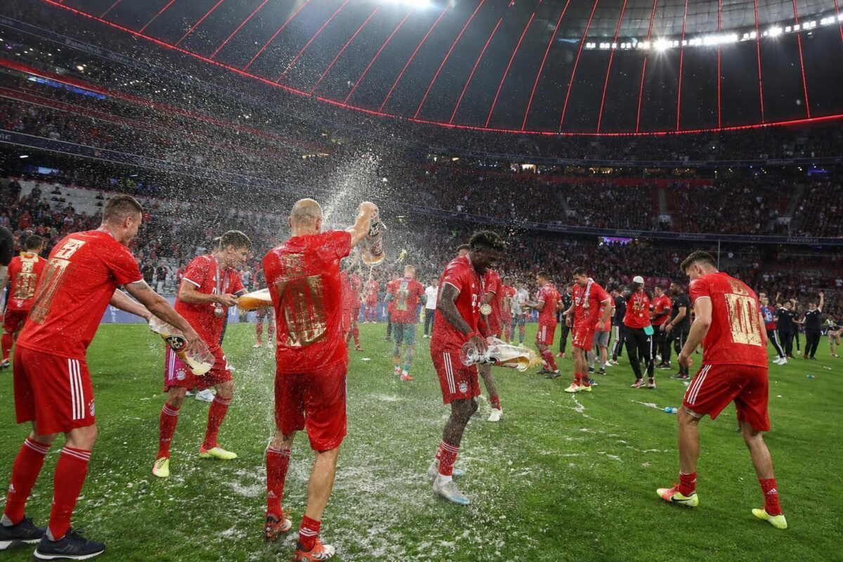 Sfeerbeeld van het titelfeest van Bayern München met bierdouches op het veld