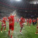 Sfeerbeeld van het titelfeest van Bayern München met bierdouches op het veld