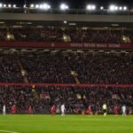 Sfeershot in en rond Anfield met gespannen wedstrijdcontext, zonder herkenbare gezichten.