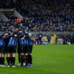 Spelers van Club Brugge vieren samen op het veld na een wedstrijd, met het stadion op de achtergrond.