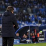Antonio Conte aan de zijlijn bij Napoli tijdens een wedstrijd, met stadionlichten op de achtergrond