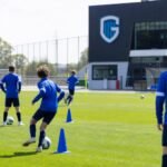 Jeugdspelers van KRC Genk op training op een oefenveld, zonder herkenbare gezichten.
