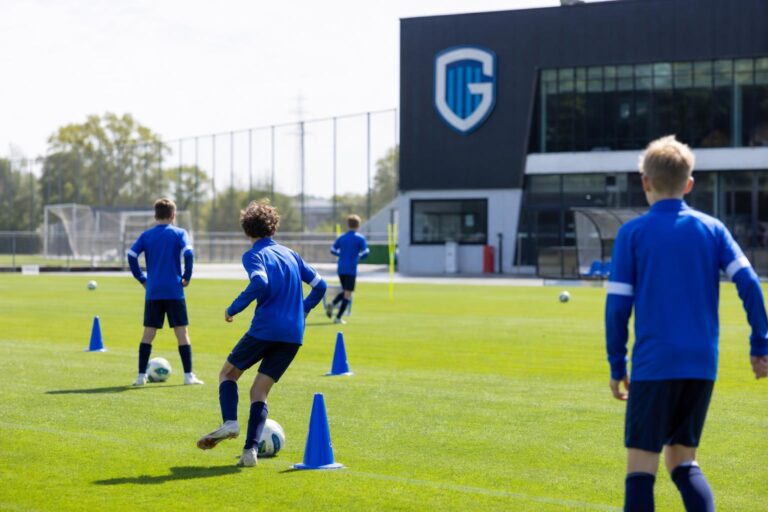 Jeugdspelers van KRC Genk op training op een oefenveld, zonder herkenbare gezichten.