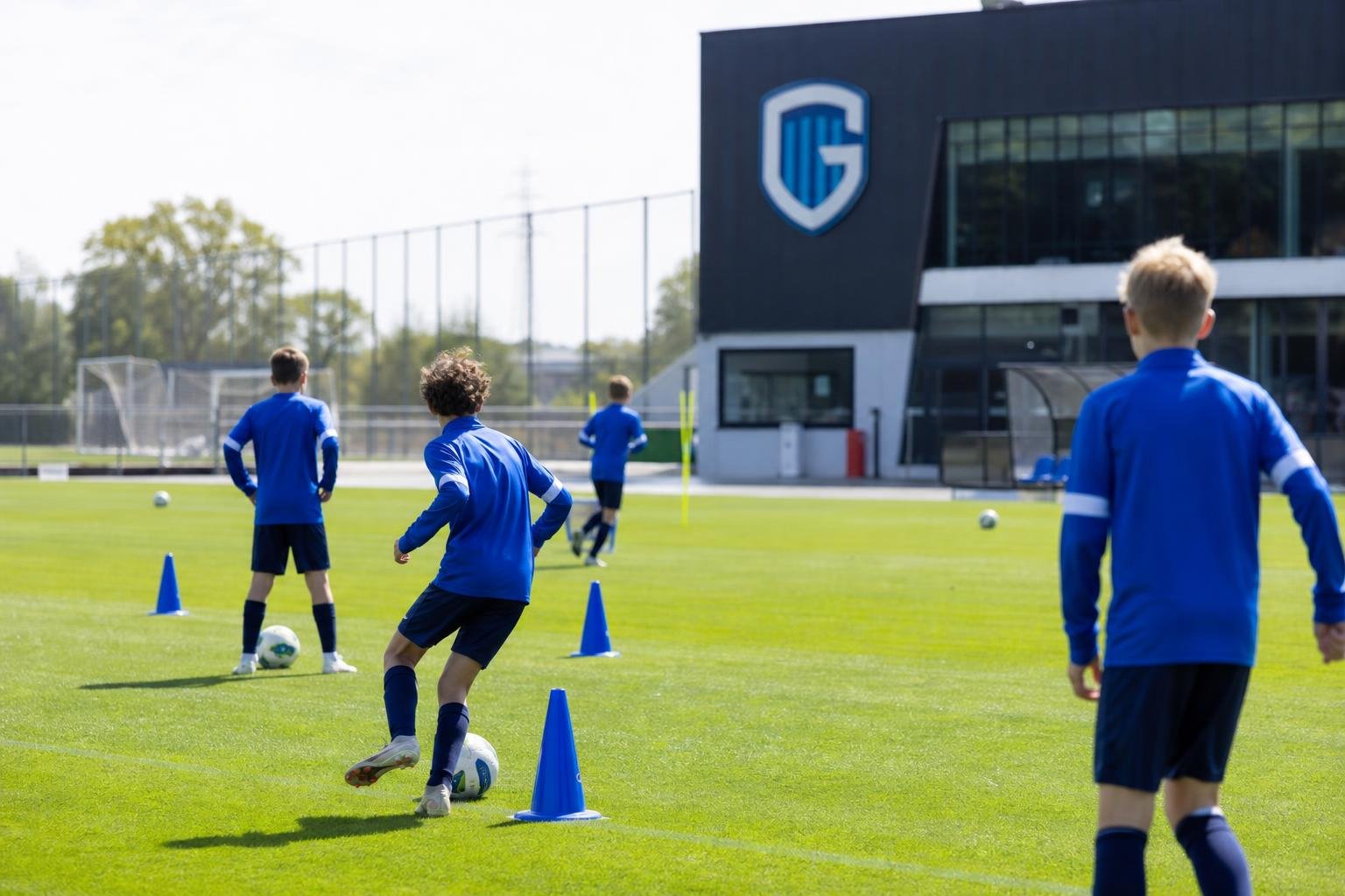 Jeugdspelers van KRC Genk op training op een oefenveld, zonder herkenbare gezichten.