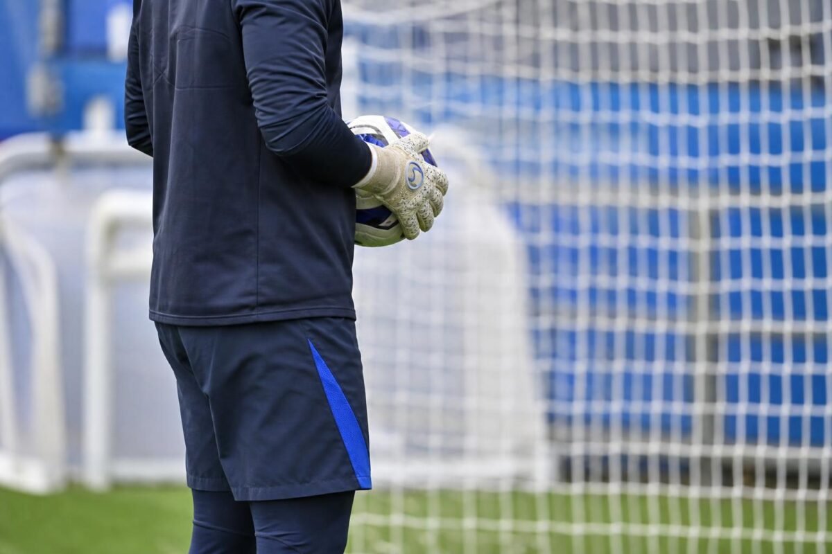 Mike Penders in keepersoutfit tijdens een trainingsmoment, met focus op handschoenen en doelgebied.