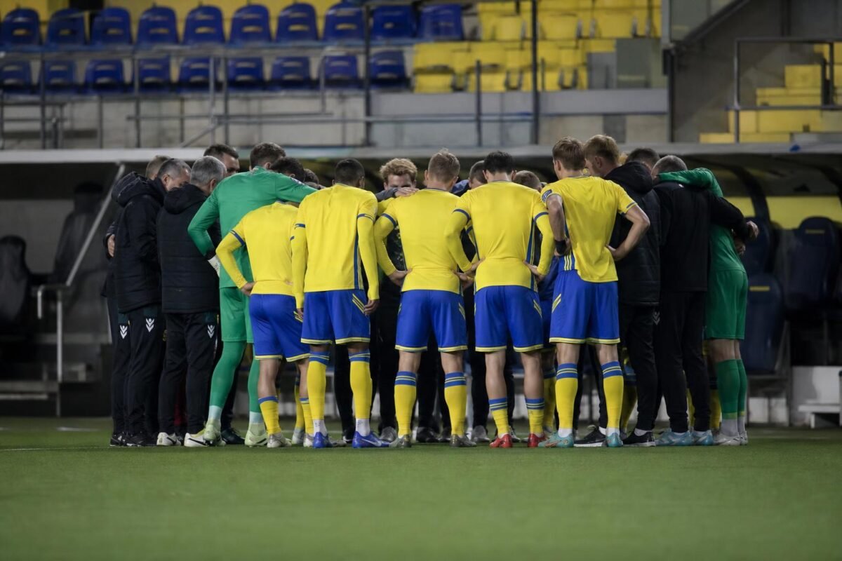 Sfeerbeeld van STVV-spelers in geel-blauw tijdens een wedstrijd, met focus op het teammoment zonder herkenbare gezichten.