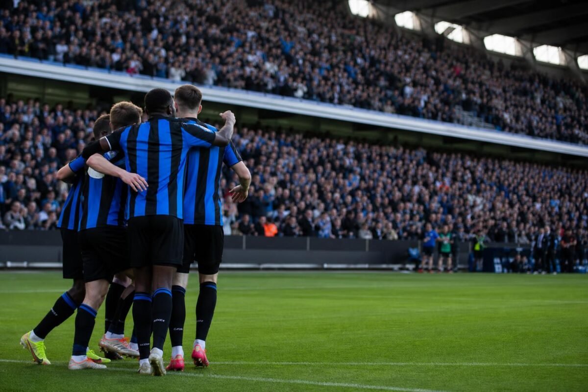 Spelers van Club Brugge vieren een doelpunt met het publiek op de achtergrond