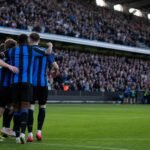 Spelers van Club Brugge vieren een doelpunt met het publiek op de achtergrond