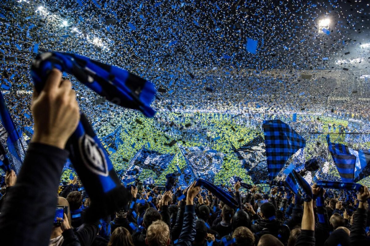 Club Brugge-supporters in titelsfeer met blauw-zwarte sjaals, zonder herkenbare gezichten