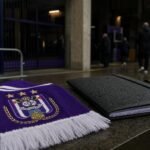 Transfercontext rond Anderlecht met paars-witte clubsfeer aan een stadioningang.