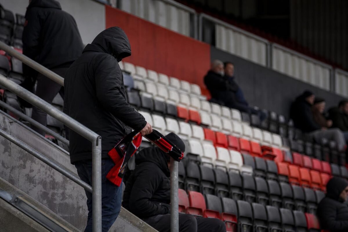 Ontgoochelde supporters in een voetbalstadion na de licentiedreun rond RWDM Brussels