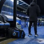 Stadionomgeving met blauwe en zwarte clubkleuren rond Club NXT na het 1B-verdict