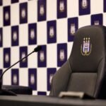 Lege trainersstoel en microfoons in een gespannen Anderlecht-perscontext