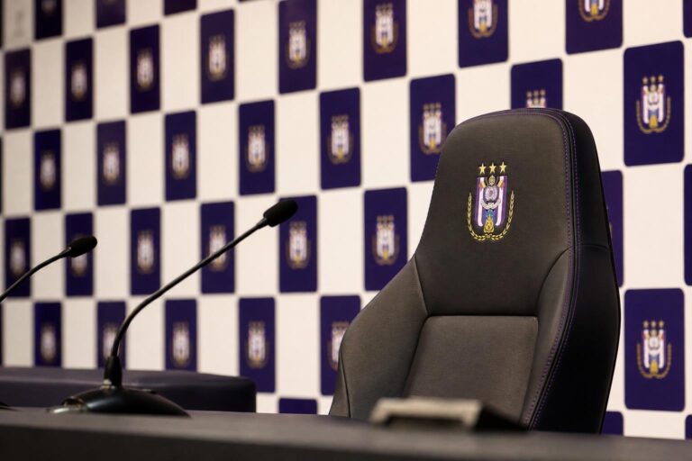 Lege trainersstoel en microfoons in een gespannen Anderlecht-perscontext