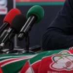 Gespannen perscontext rond Zulte Waregem met microfoons en clubkleuren