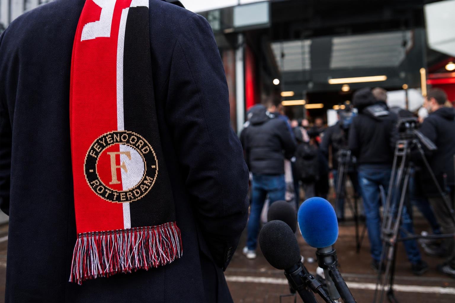 Een realistische perssetting rond een mogelijke aanstelling bij Feyenoord, zonder herkenbare gezichten.