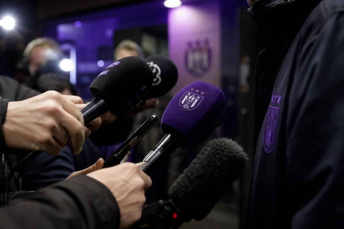 Gespannen persomgeving rond Anderlecht met microfoons en paars-zwarte sfeer zonder herkenbare personen