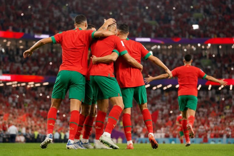 Marokkaanse spelers vieren een doelpunt in een WK-stadion zonder herkenbare gezichten