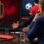 Gespannen voetbalstudio met microfoons rond de discussie over Jérémy Doku en vaderschap