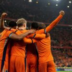 Nederlandse spelers vieren een doelpunt voor een vol stadion