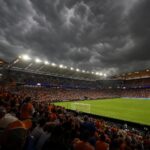 Dreigende onweerslucht boven een open voetbalstadion voor Nederland-Tunesië op het WK.