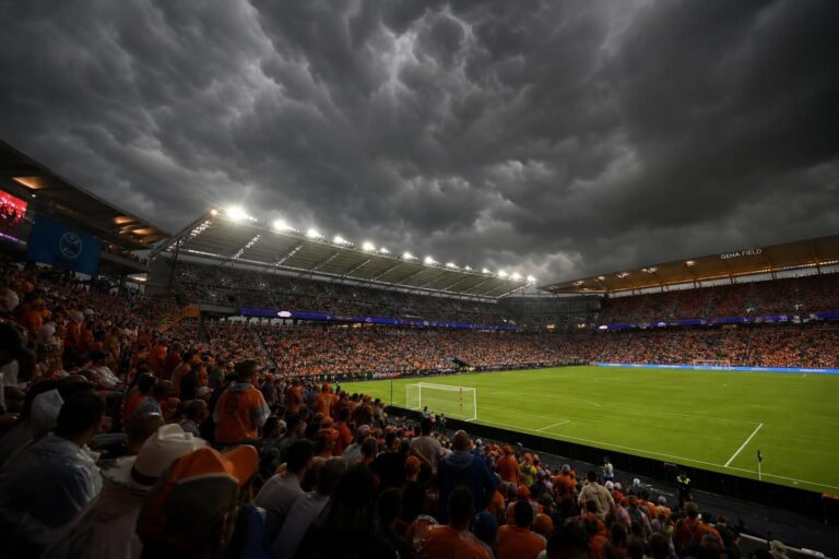 Dreigende onweerslucht boven een open voetbalstadion voor Nederland-Tunesië op het WK.