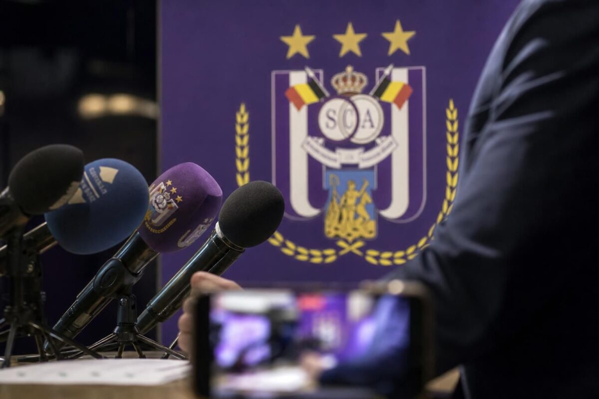 Persmoment rond RSC Anderlecht met transferdruk en microfoons zonder herkenbare gezichten