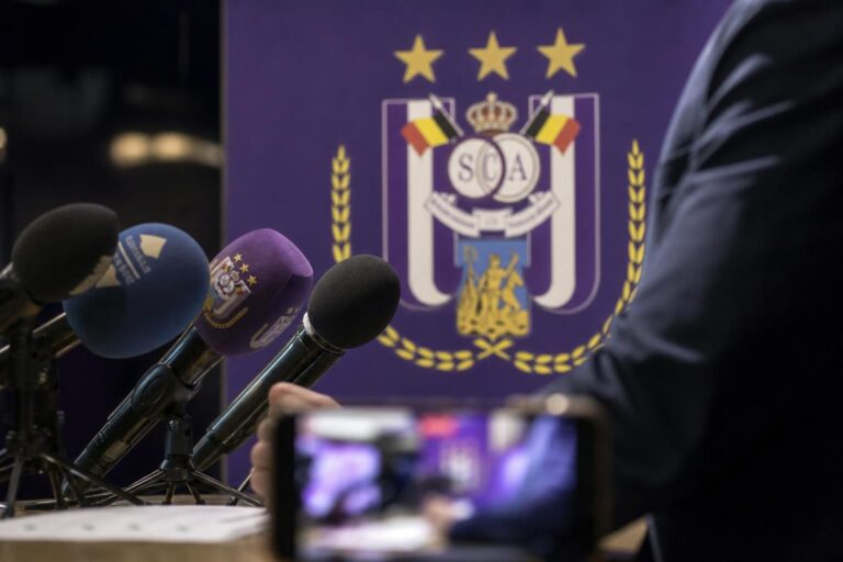 Persmoment rond RSC Anderlecht met transferdruk en microfoons zonder herkenbare gezichten
