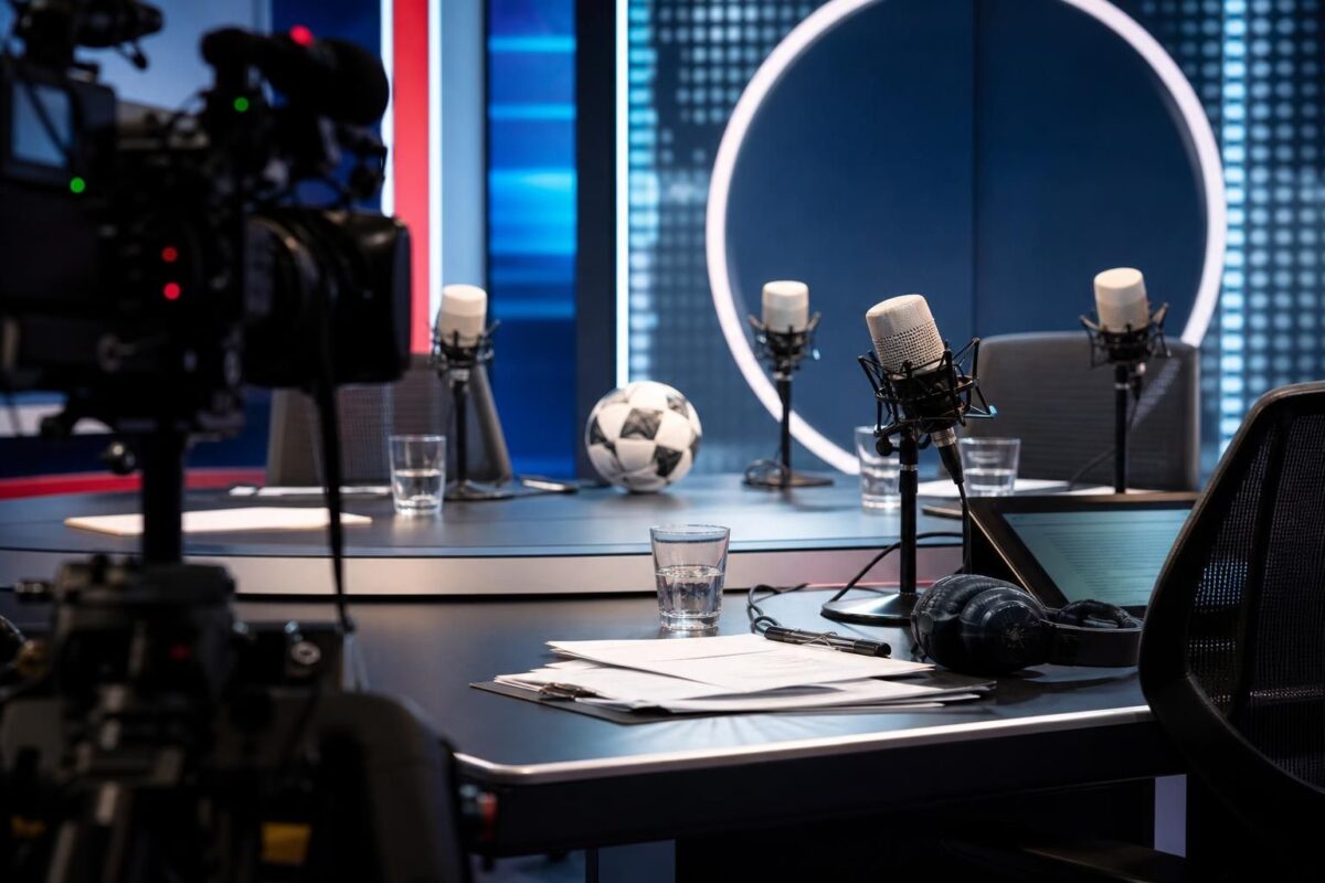 Sporttalkshowstudio met camera's en microfoons rond een voetbalgerichte uitzending