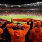 Oranje-supporters in een WK-stadionomgeving rond de discussie over dure tickets