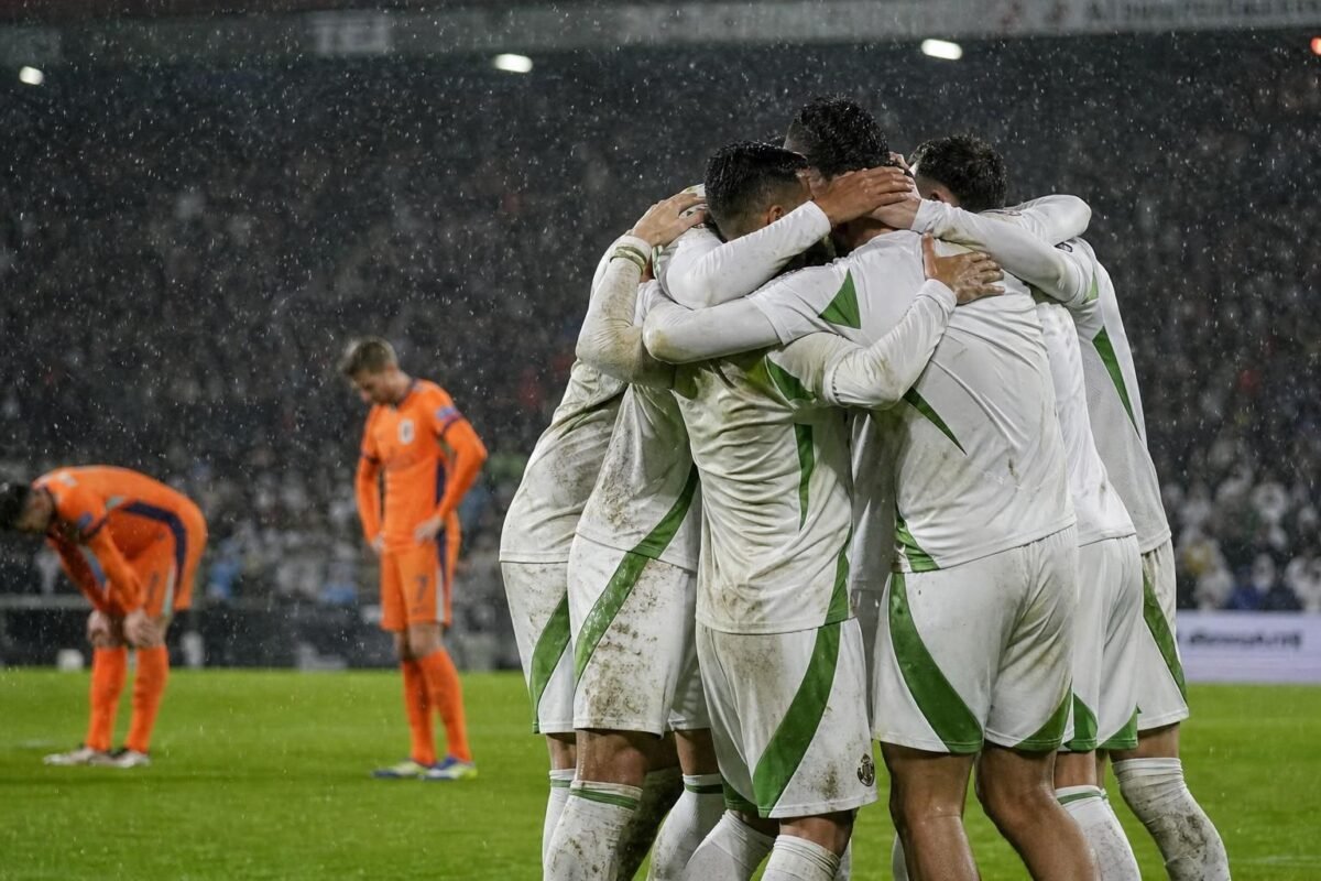 Algerijnse spelers vieren een late goal tegen Nederland in een regenachtige De Kuip zonder herkenbare gezichten